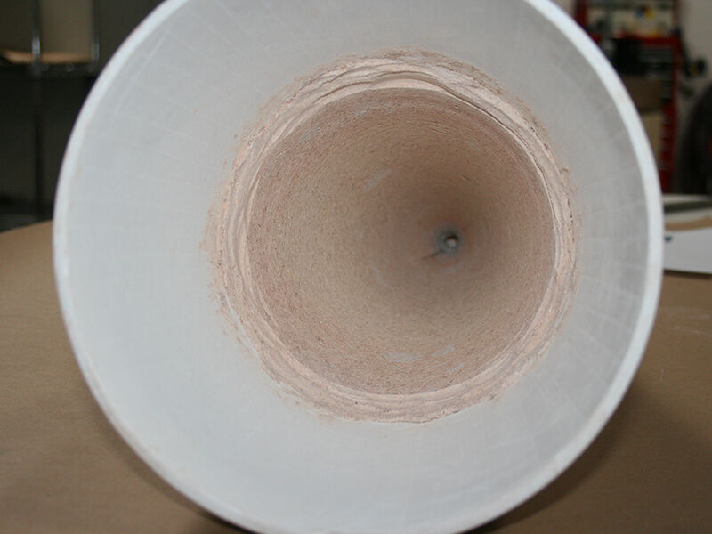 Image of white, cone-shaped,, ceramic matrix composite radome laying on its side. It shows the inside of the cone, which includes a thin, tan parasitic layer applied to the interior surface.